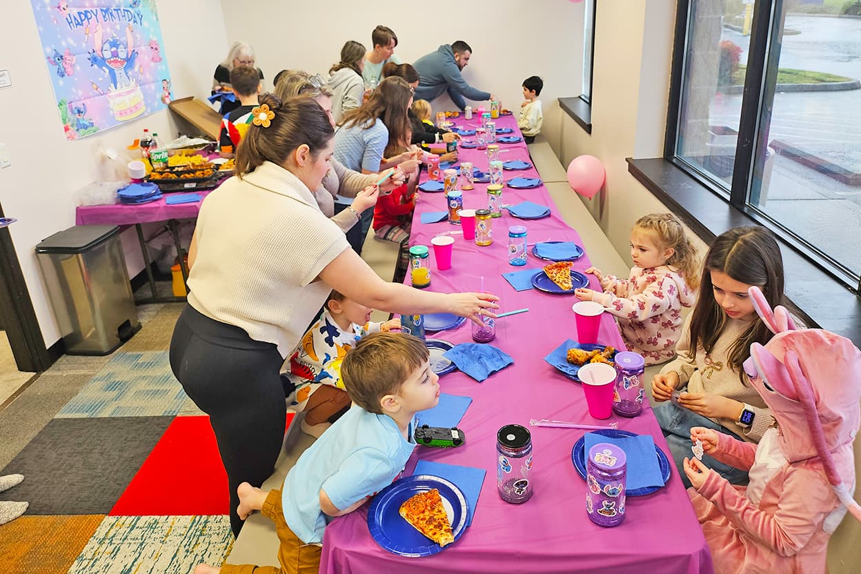 Parents helping kids at birthday party table