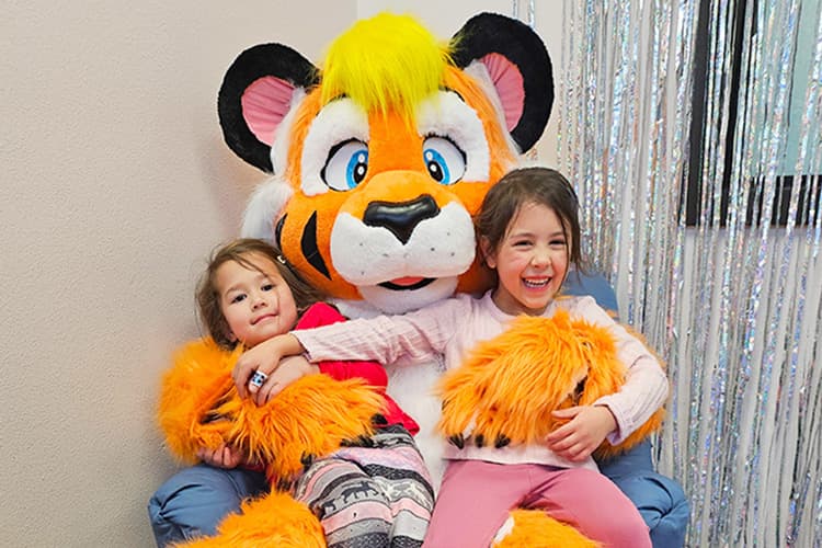 Kids Sitting with Tiger Mascot